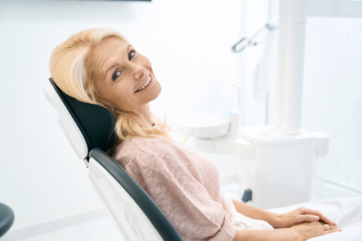Mature woman relaxing in dental chair during examination at modern dental office.